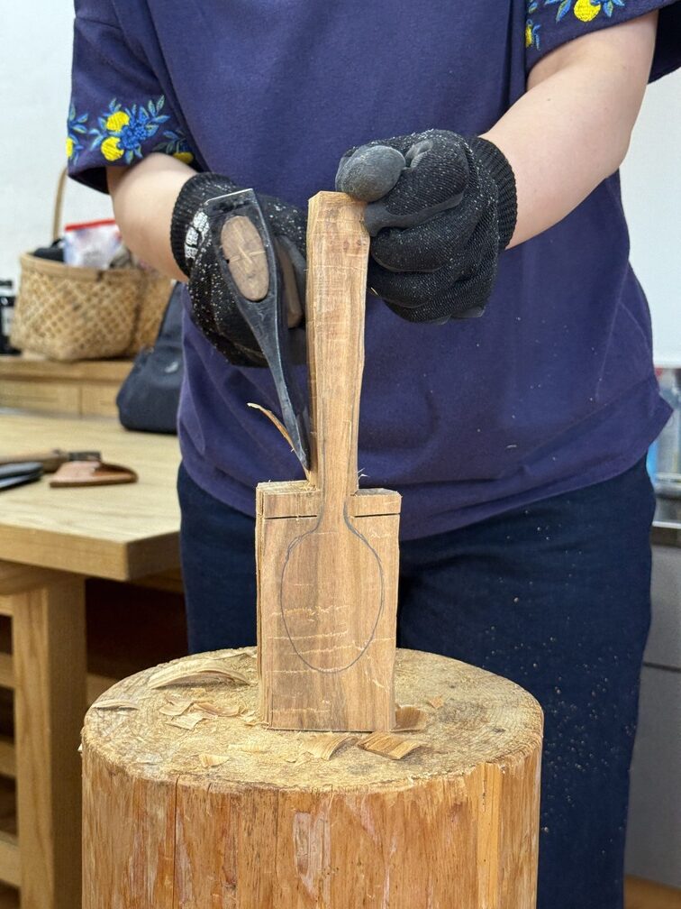 斧で木を削りスプーンをつくっている様子