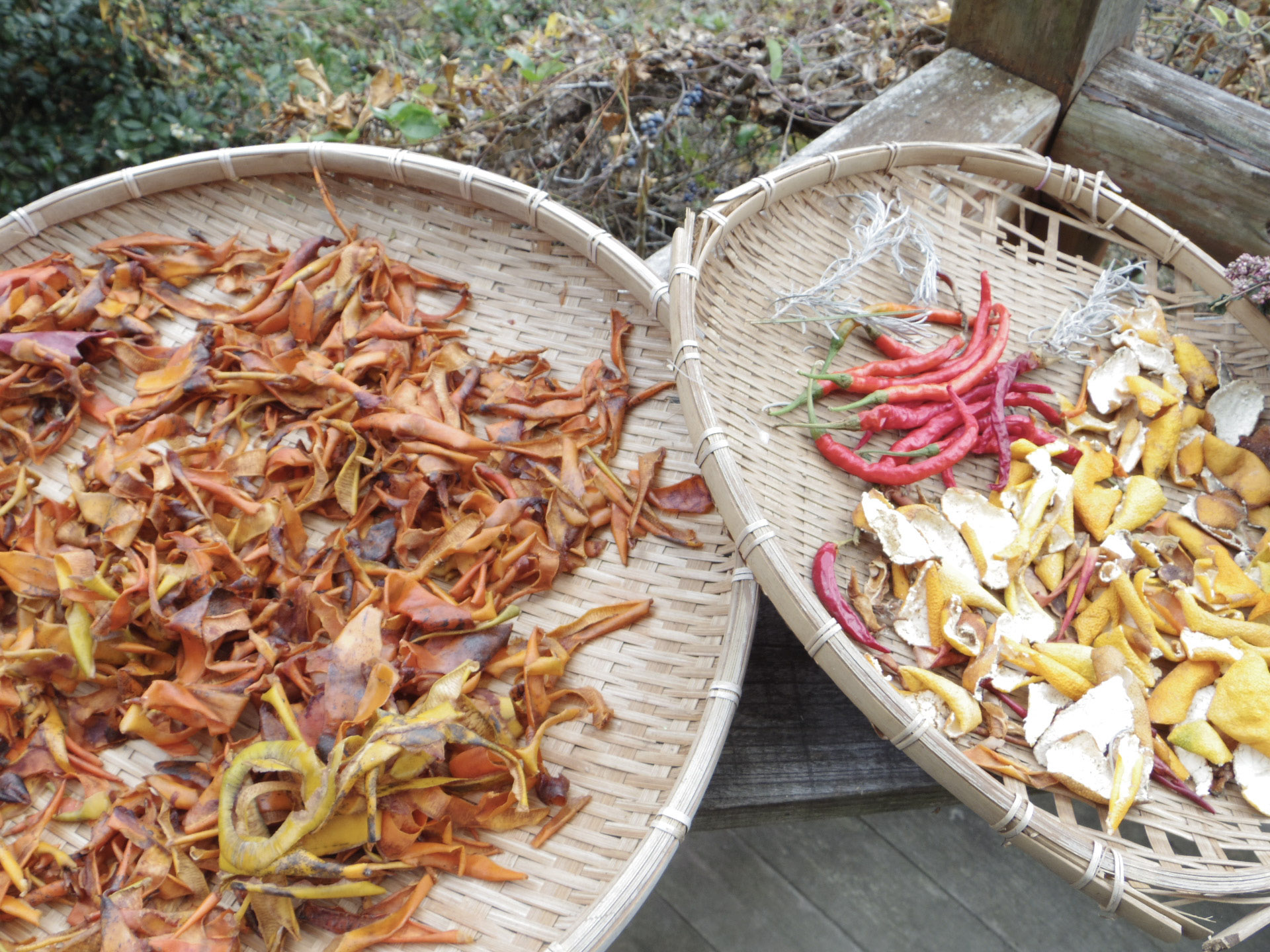 みかんの皮や唐辛子、ハーブにお花など、色とりどりの素材を並べて乾燥中。