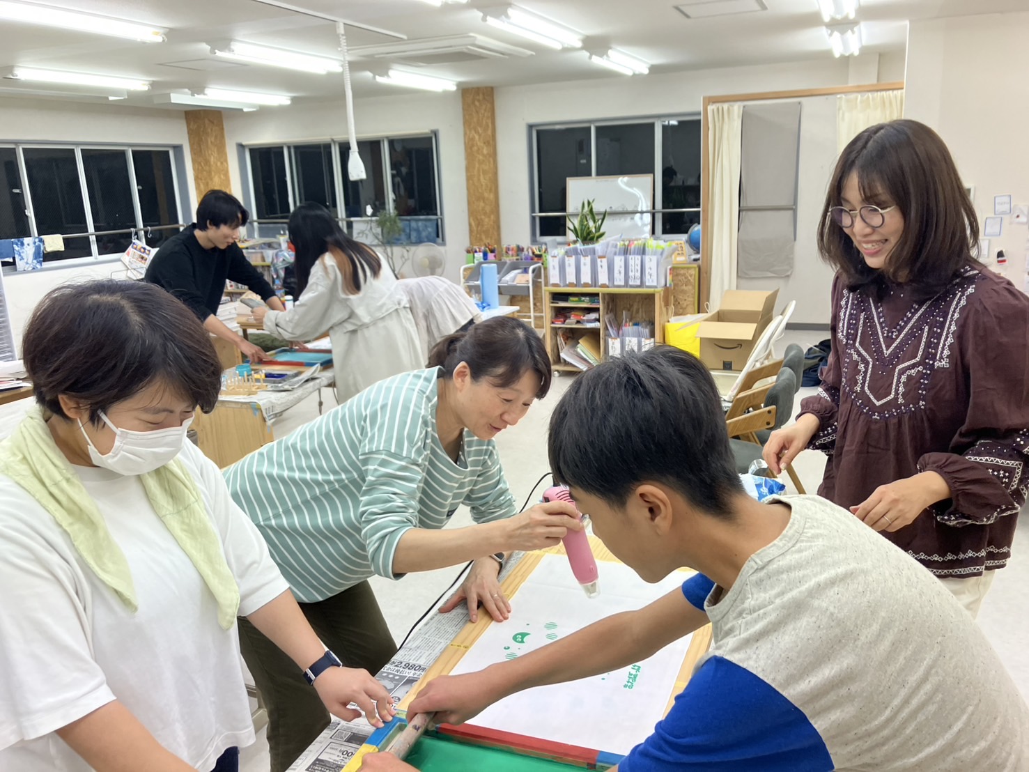 あそまなオリジナルの手ぬぐいづくり。押さえる人、刷る人、乾かす人、となんとなく役割分担して手ぬぐいを刷る。